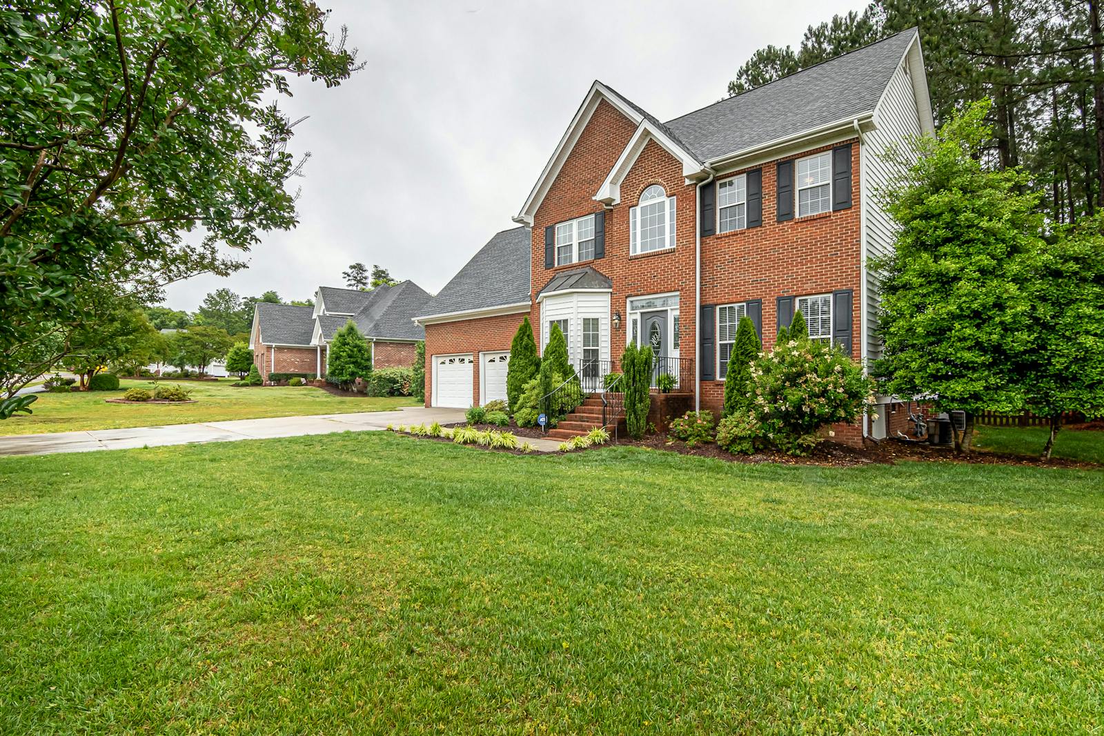 Two-story brick house with a wide green lawn